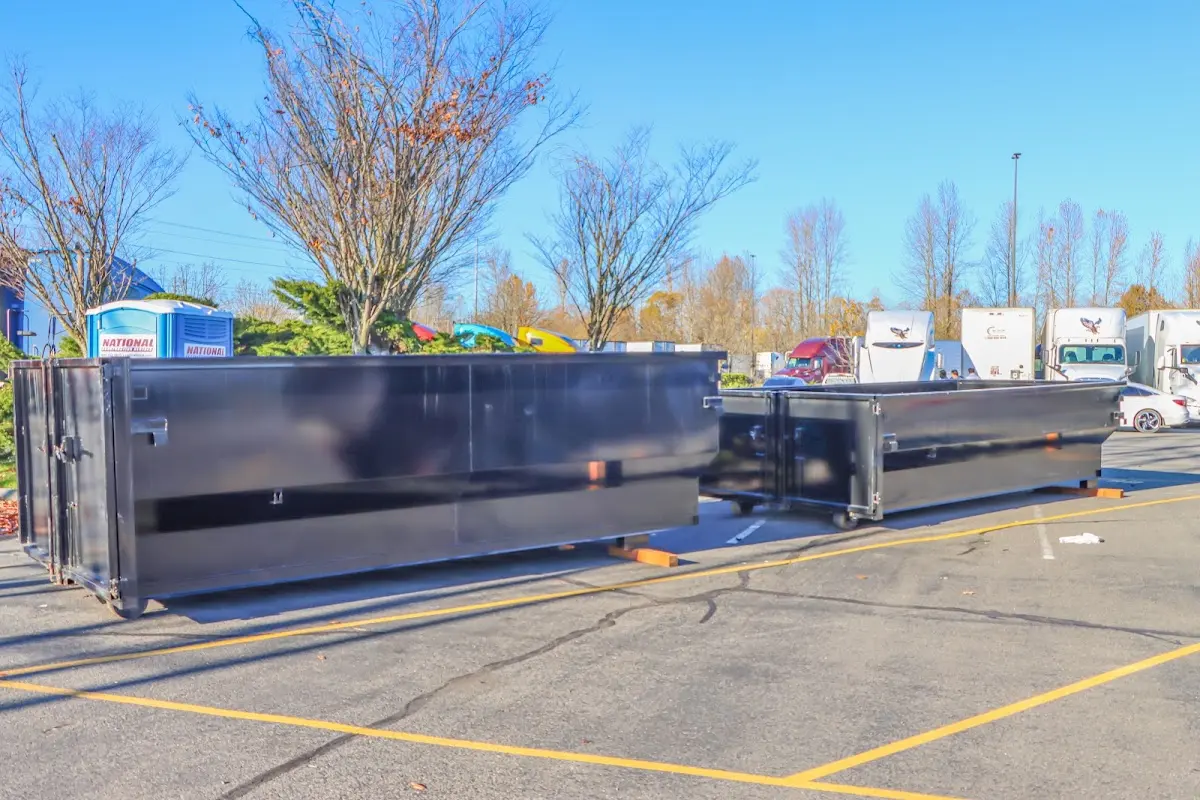 Professional dumpster rental service with roll-off container on residential driveway in Fulton